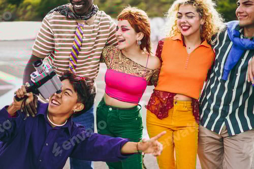 Preview: Young Diverse People Having Fun With Old Vintage Video Camera Outdoor - Soft Focus On Left Girl Face