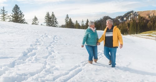 Preview: Happy Senior Couple Walking Together Through The Snow During Winter Time - Joyful Elderly People