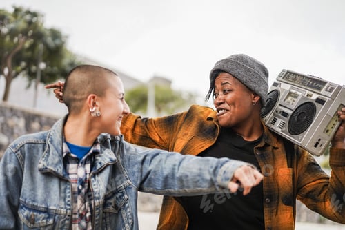 Preview: Multiracial Young Women Dancing Outdoor With Urban Background - Trendy Street Wear Style And