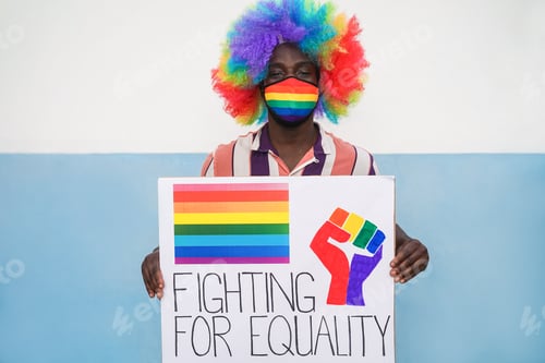 Preview: African Man Holding Lgbt Banner At Gay Pride Demonstration While Wearing Rainbow Safety Mask