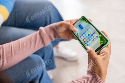 Preview: Young Girl Playing Video Game On Mobile Phone App - Focus On Right Hand