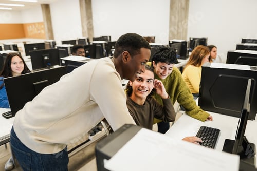 Preview: Young Multiracial Students Using Computers During Business Class At School - Focus On Center Guy