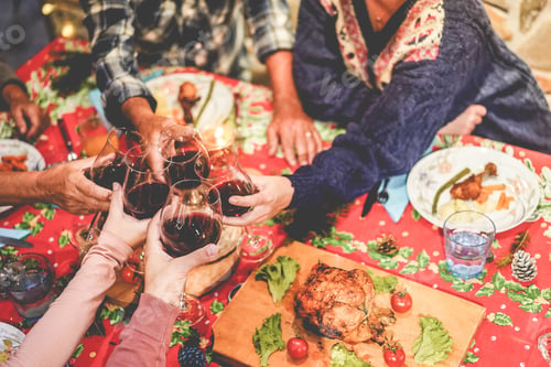 Preview: Hands View Of Family Cheering With Red Wine While Eating Dinner Together - People From Different