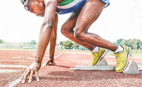 Preview: Afro American Runner Using Starting Block To Start His Run On Race Track - Young Athlete Starting