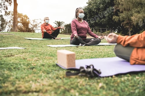 Preview: People Doing Yoga Class Outdoor Sitting On Grass While Wearing Safety Masks During Coronavirus