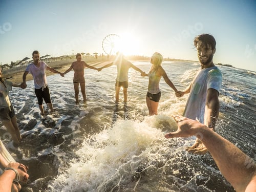 Preview: Firsthand View Of Happy Friends Having Fun On The Beach At Sunset - Young People Playing Inside Sea