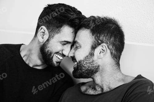 Preview: Gay Men Couple Having Tender Moment Together At Home - Soft Focus On Left Man Eye - Black And White