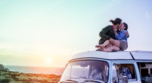 Preview: Happy Couple Kissing On Top Of Minivan Roof At Sunset - Young People Having Fun On Summer Beach