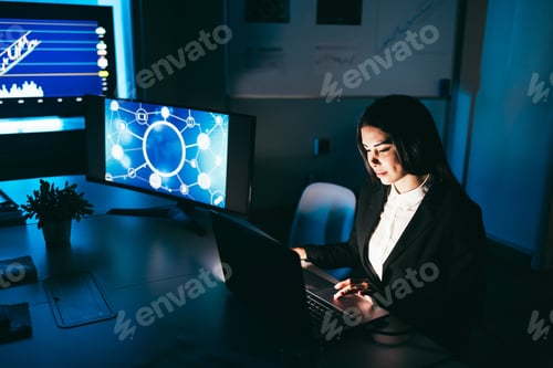 Preview: Young Business Woman Working At Night Inside Fintech Company Office Doing Blockchain Research