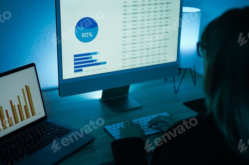 Preview: Young Woman Analyzing Data Charts For Marketing Financial Reports - Focus On Left Computer Screen