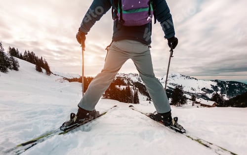 Preview: Ski Athlete Standing In Front Of Sunset On Top Of The Mountain - Legs View Of Young Skier With Sun