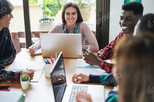 Preview: Multiracial Students Using Laptop Computers While Studying Together At School - Focus On Center