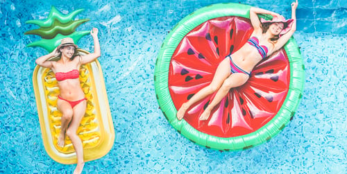 Preview: Happy Girls Floating With Tropical Fruit Lilos Inside Swimming Pool - Young Women Friends Relaxing