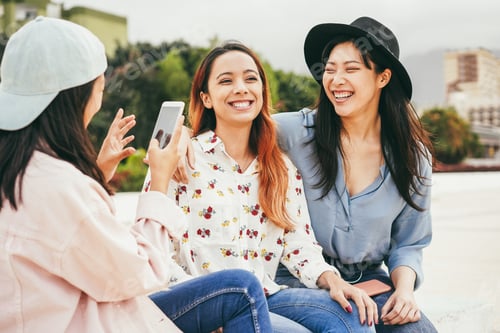 Preview: Happy Asian People Having Fun Using Mobile Phone Outdoor - Focus On Center Girl Face