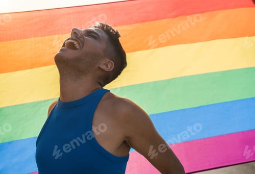 Preview: Young Transgender Man With Makeup Smiling With Lgbt Rainbow Flag On Background