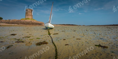Preview: A Wide Shot Of A White Boat On The Sandy Beach With Ta Brick Tower And The Clear Blue Sky In The