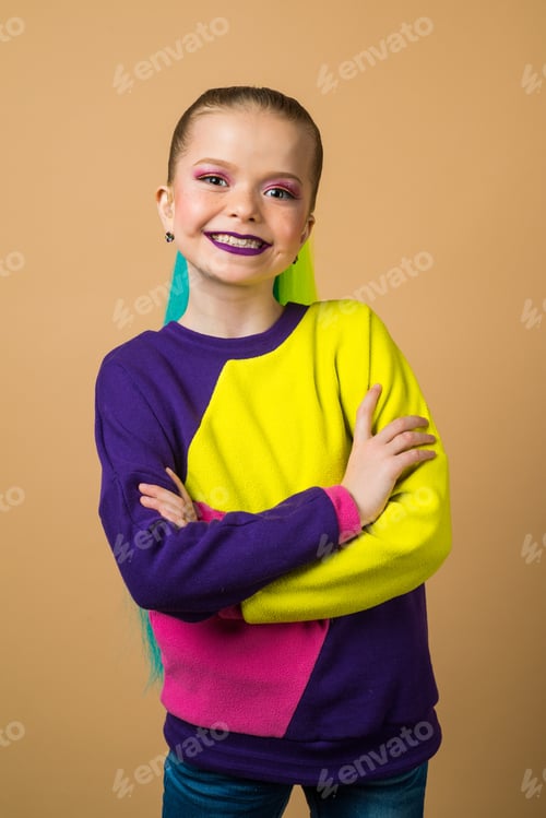 Preview: Adorable Little Girl In Casual Clothes Posing On Camera. Studio Portrait Of Schoolgirl With