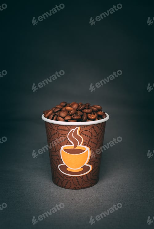 Preview: A Vertical Shot Of A Printed Cup Full Of Roasted Coffee Beans Isolated On Dark Background