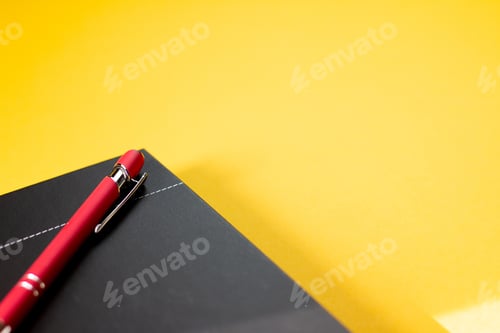 Preview: A Closeup Shot Of A Notebook And A Pen Isolated On A Yellow Background