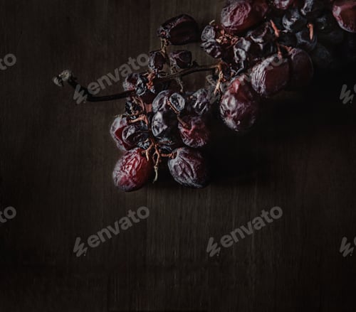 Preview: A Closeup Of Dark Dried Grapes In The Dark Wood Background