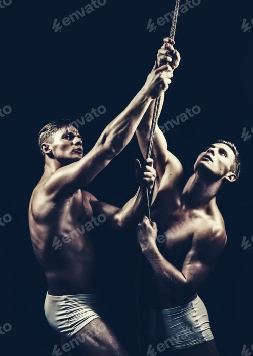Preview: Athlete Men Training With Rope. Athlete Twins Men Isolated On Black Background
