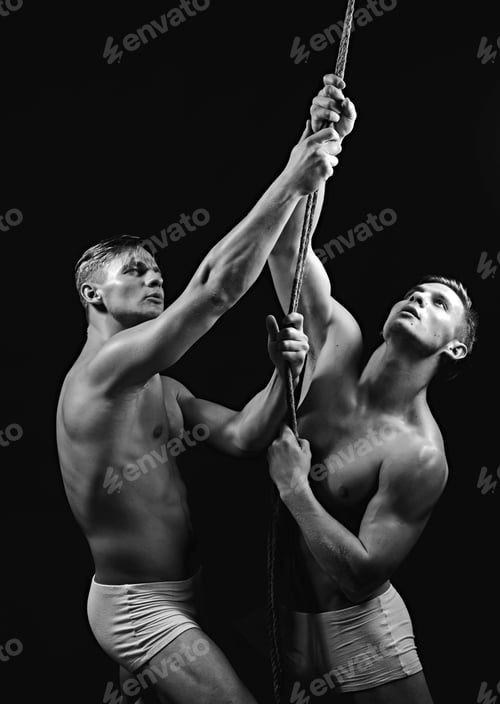 Preview: Athlete Men Training With Rope. Athlete Twins Men Isolated On Black Background