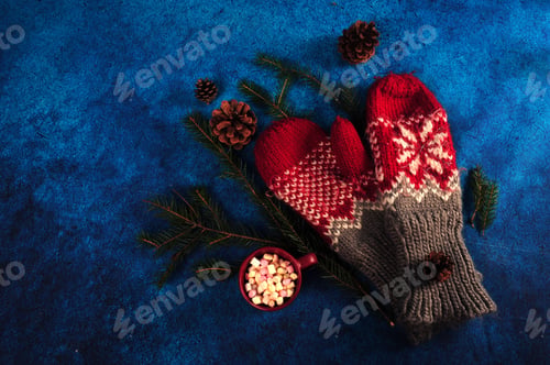 Preview: A Top View Of Warm Mittens And A Cup Filled With Marshmallow Decorated With Needles And Pines