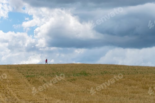 Preview: A Woman Walking In A Plantation Field On An Amazing Agricultural Landscape With A Dramatic Sky Near