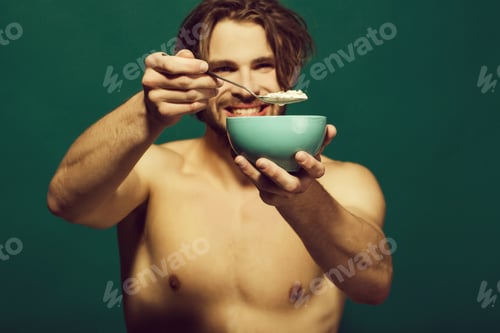 Preview: Healthy Food. Happy Man With Bare Chest Eating Breakfast Of Oatmeal With Milk In Bowl With Spoon On