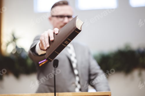 Preview: A Selective Focus Shot Of A Male Standing And Holding A Book In Hands