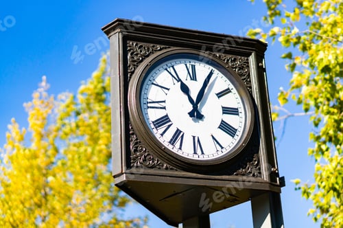 Preview: A Low Angle Shot Of An Outdoor Clock On A Pipe In A Park Under The Sunlight