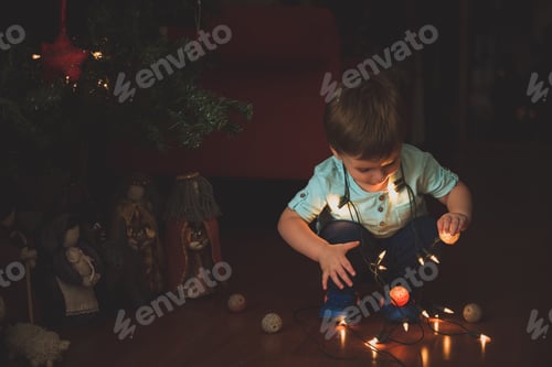 Preview: Toddler Plays with Christmas Lights Near Nativity Scene