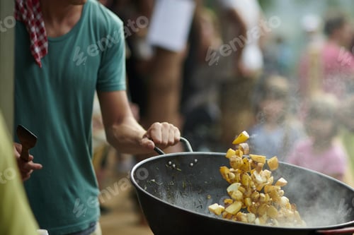 Preview: A Male Holding A Frying Pan With Fried Potatoes In It