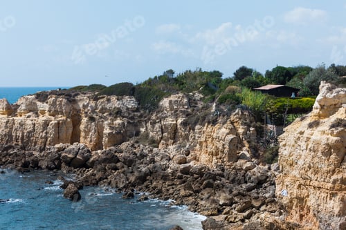 Preview: Sea Stacks And Rock Cliffs At A Shore Under A Bright Sky