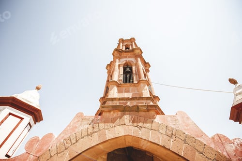 Preview: A Low Angle Shot Of A Church Bell Tower With A Blue Sky In The Background