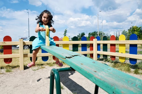 Preview: Little Latin Girl Playing On The Broken See Saw.