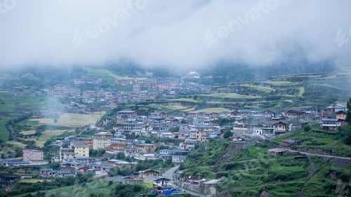 Preview: The Houses Of A Small Town Surrounded By Forests And A Foggy Cloud