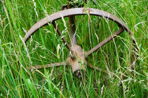 Preview: A Closeup Shot Of Rusty Wheel Rural Equipment In A Grass Field