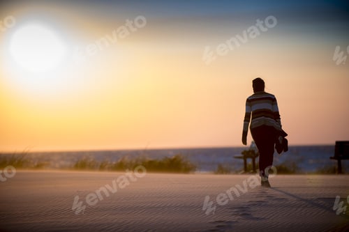 Preview: A Beautiful Shot Of A Female Walking On A Sandy Shore Leaving Footprints Behind
