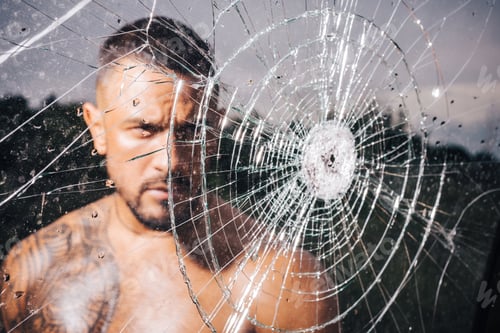 Preview: Macho Man Glasscutter Behind Crushed Glass. Sexy Hispanic Man Broken Mirror. Bullet Hole In Glass