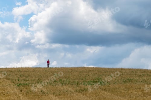 Preview: A Woman Walking In A Plantation Field On An Amazing Agricultural Landscape With A Dramatic Sky Near