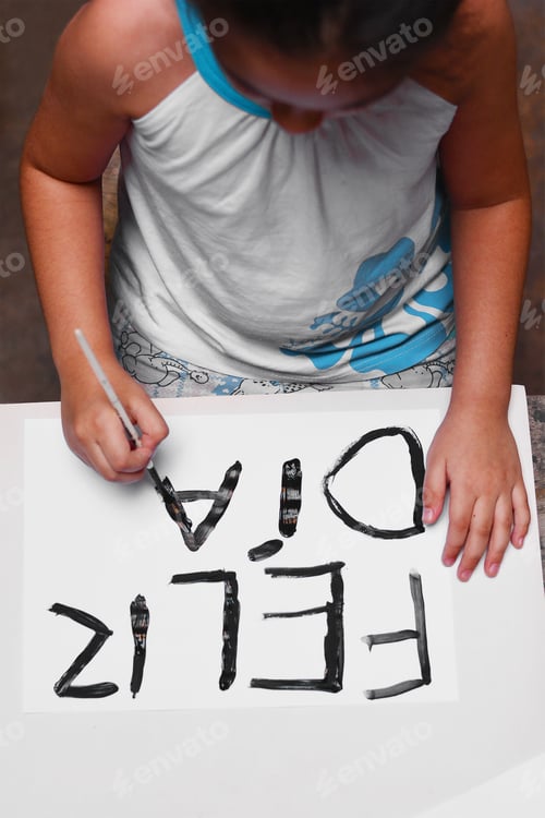 Preview: Little Latin Kid Writing Greeting Card That Says In Spanish: "Happy Day!"
