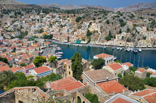 Preview: A Mesmerizing Shot Of Symi Greek Island With Buildings And Parked Boats