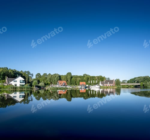 Preview: A Beautiful Shot Of Village Houses And Trees Reflecting In The Lake