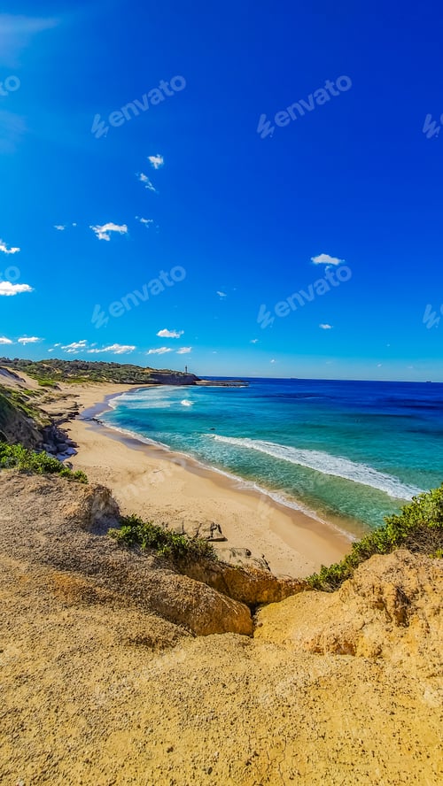 Preview: A Vertical Shot Of The Beautiful Coast Of The Sea On A Sunny Day With Amazing Blue Sky