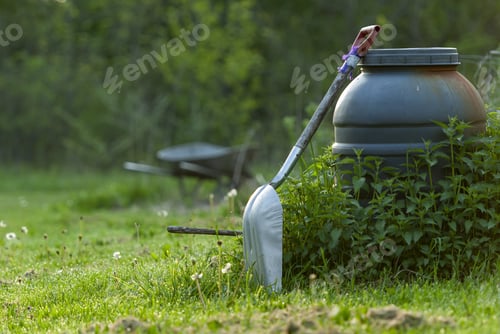 Preview: A Closeup Shot Of A Shovel In The Garden With Trees On The Background