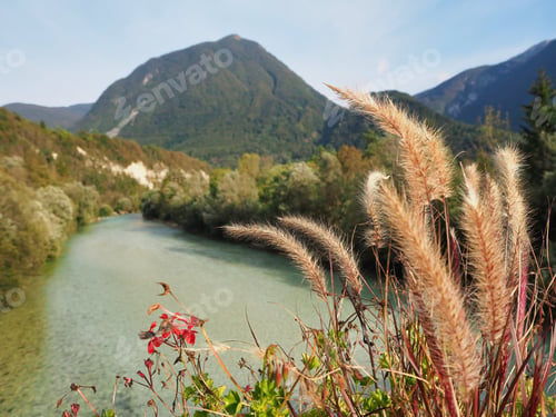 Preview: A Beautiful View Of A River Surrounded By Forested Mountains Under A Bright Sky