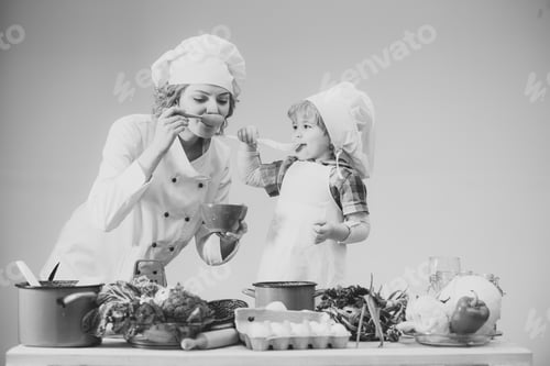 Preview: Chef And Assistant Near Kitchen Equipment And Food Products. Mother Teaches Son To Cook On Light