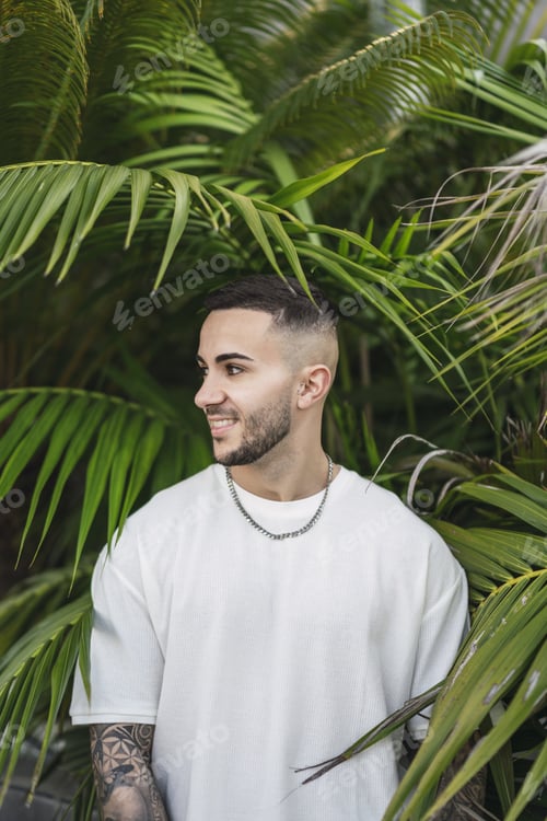 Preview: A Vertical Shot Of A Smiling European Man In A White T-Shirt Posing Against Palm Trees