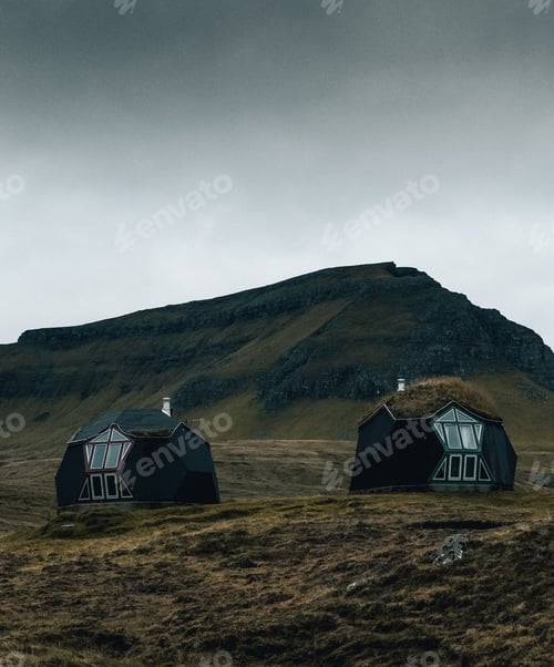 Preview: A Vertical Shot Of Two Modern Cottages In The Countryside Surrounded By Mountains